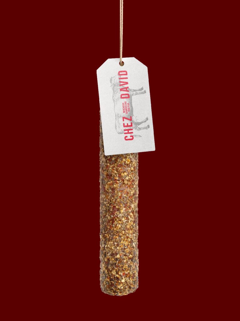 Saucisson avec étiquette Chez David sur fond bordeaux